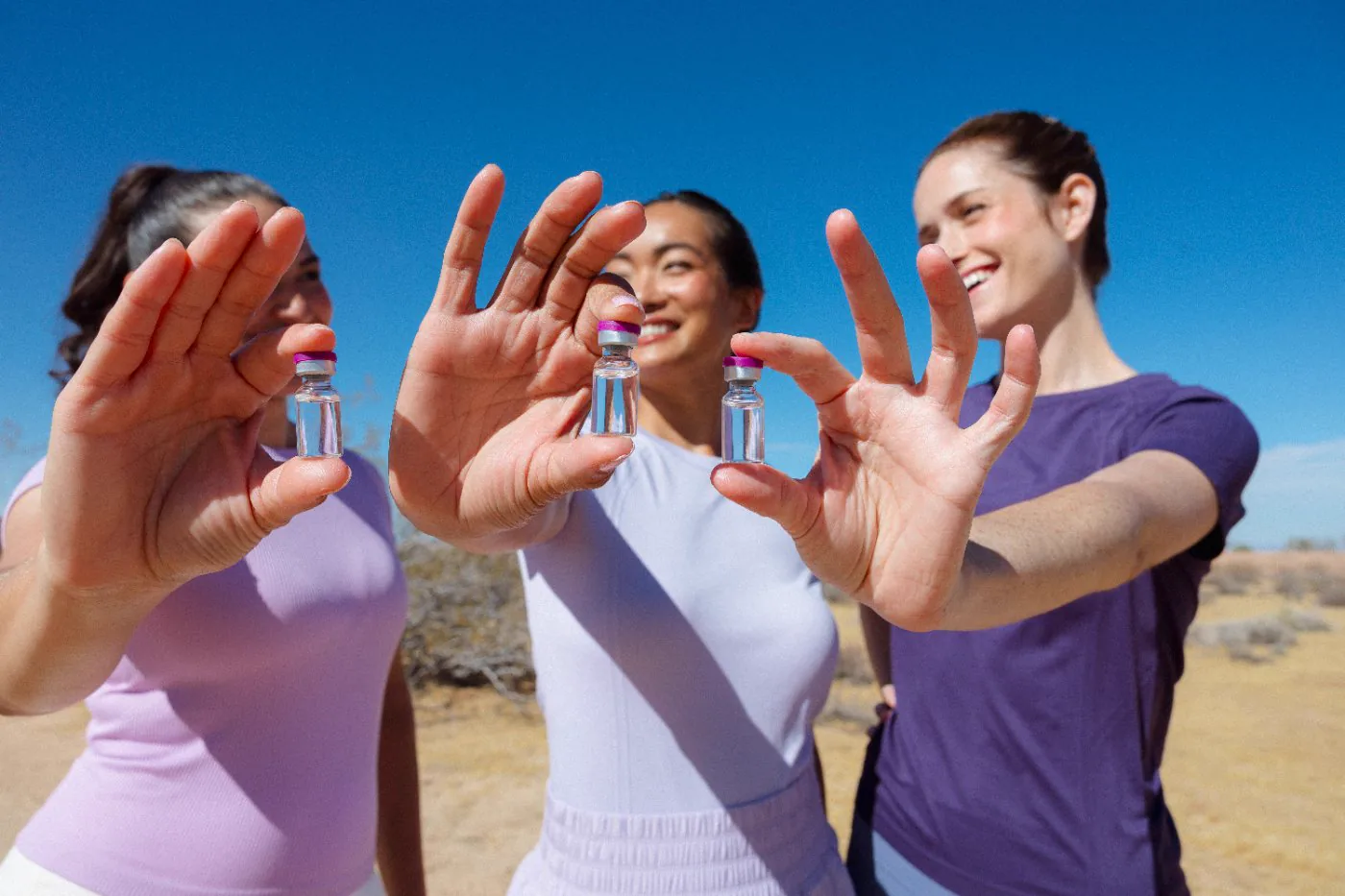 Three Brello members holding up their vials